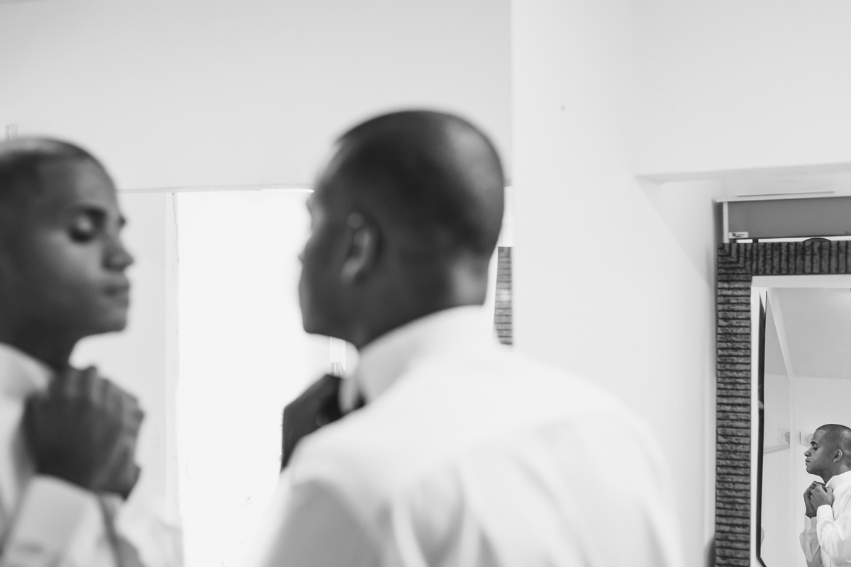Noivo se arrumando e olhando no espelho no making of no dia do casamento em Paria Grande - SP  - fotografia Cia P&B Produções 