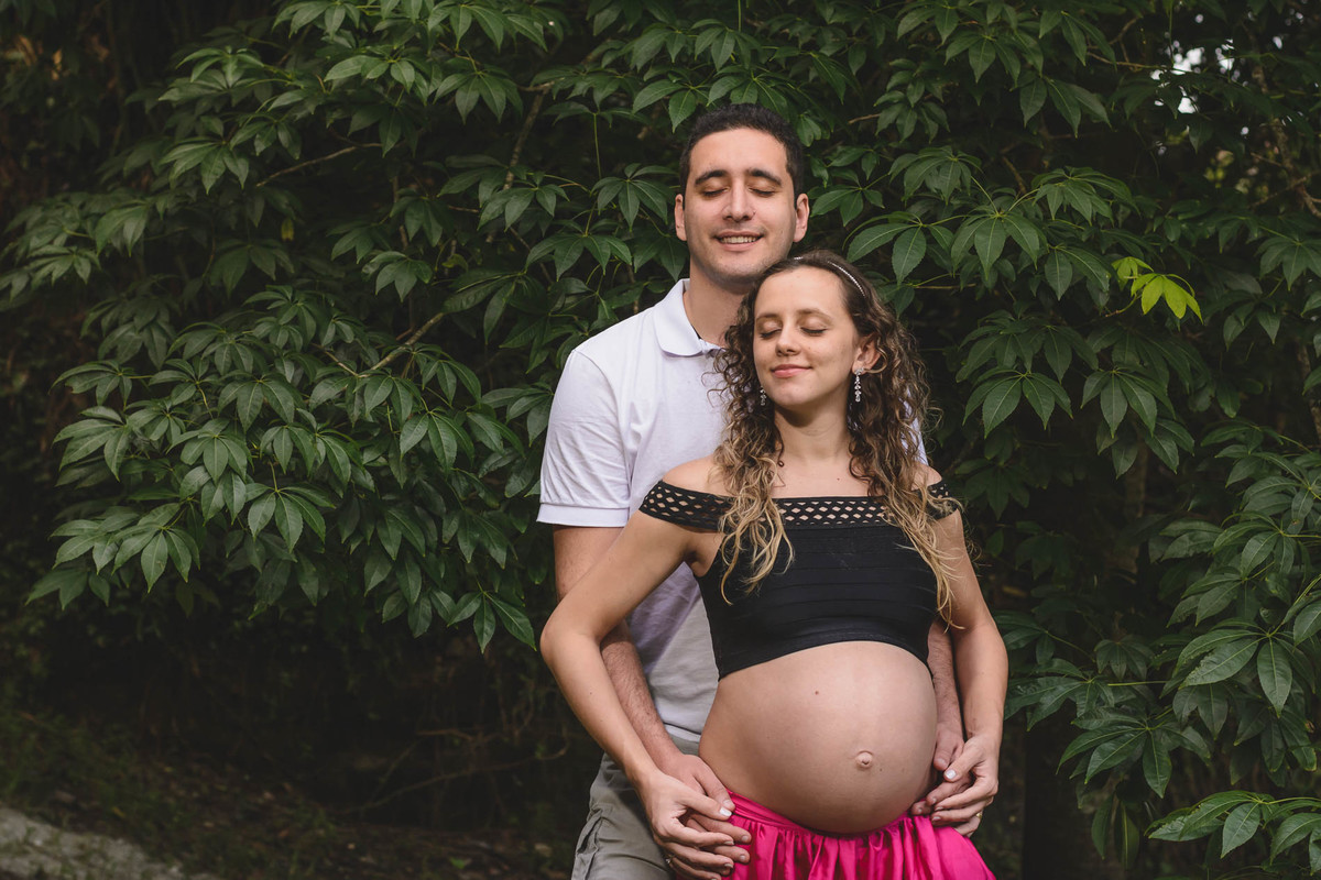 Foto da gestante e do marido e das árvores. Ensaio de gestante feito pela Cia P&B Produções Itanhaém - SP