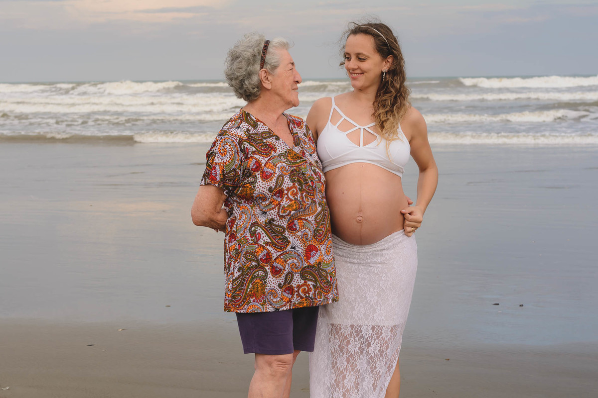 Foto da gestante com a avó na praia.Ensaio de gestante feito pela Cia P&B Produções Itanhaém - SP