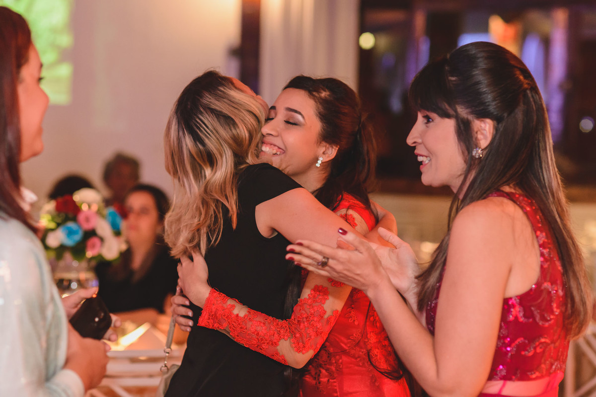Foto da debutante recebendo abraço da convidada na festa de 15 anos - fotografia Cia P&B Produções  - Buffet Maravale - Praia Grande - SP