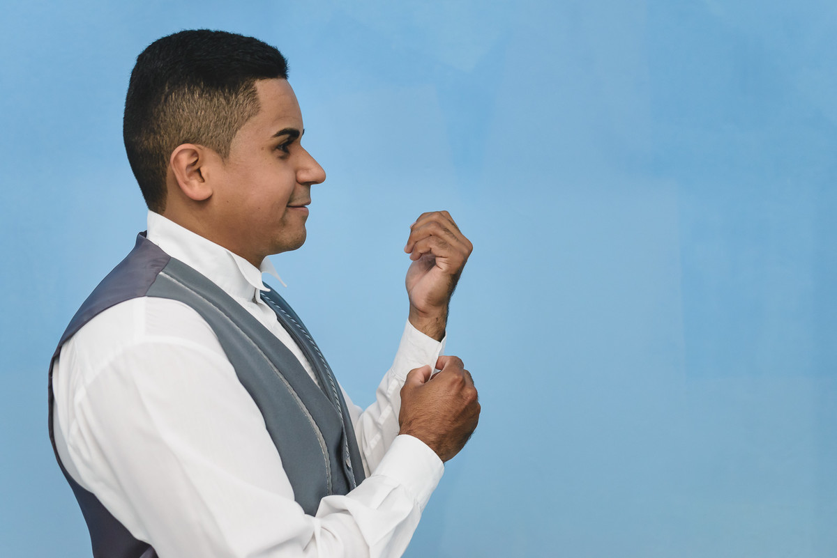 Foto do noivo abotoando a camisa no making of/dia do noivo - Mongaguá - SP - Cia P&B Produções