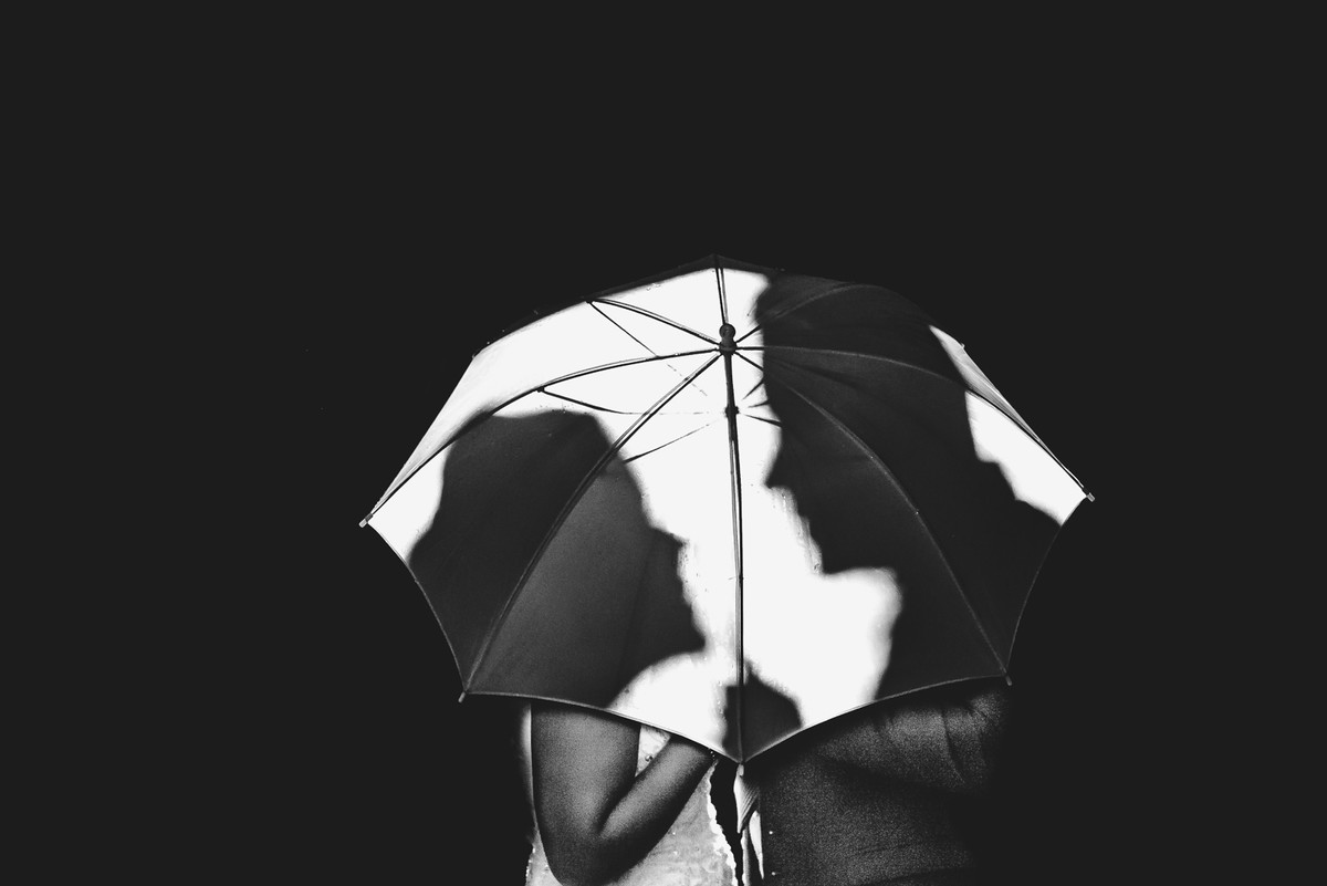Foto criativa dos noivos com o guarda chuva - Mongaguá - SP - fotografia Cia P&B Produções