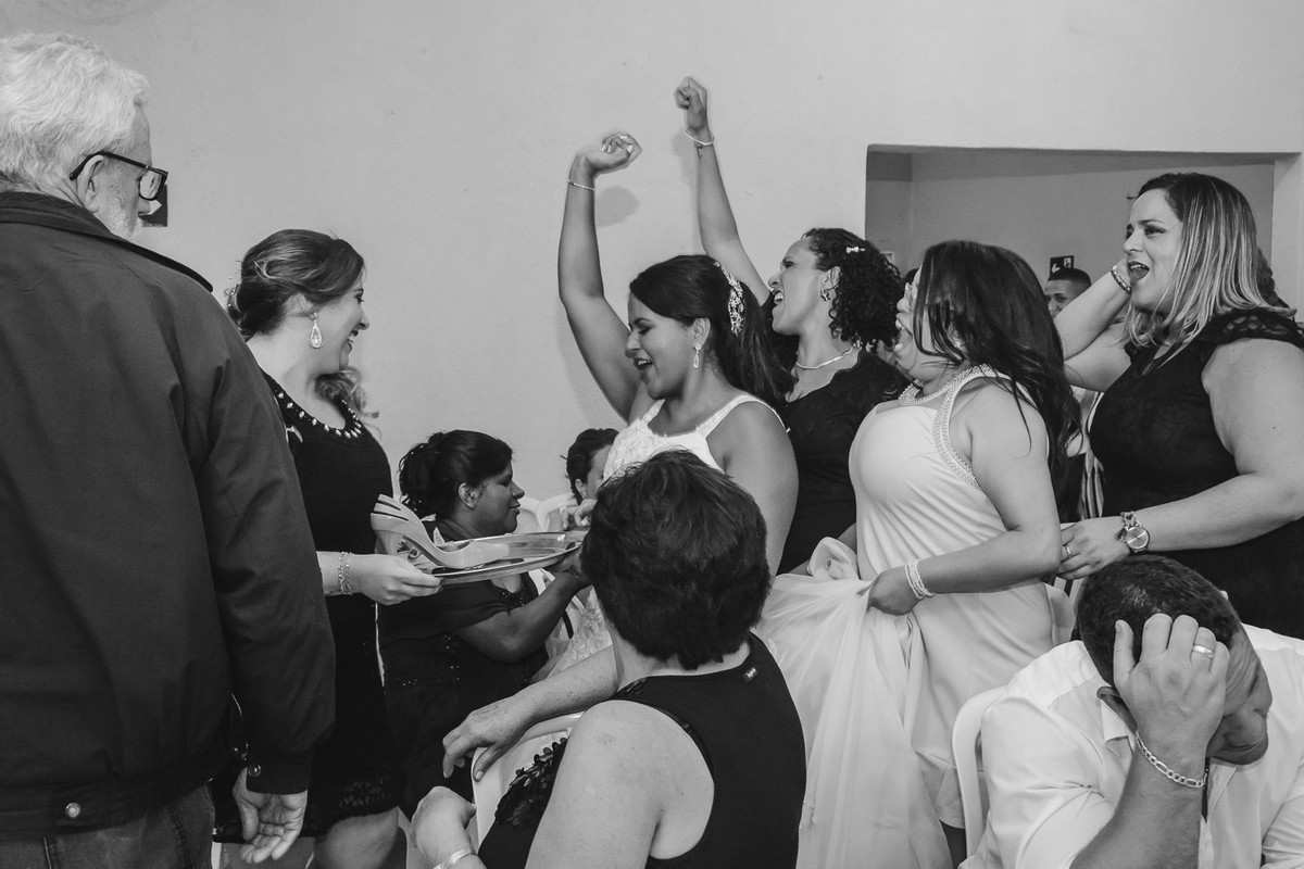 Foto da noiva com as madrinhas passando o sapato na festa de casamento- Mongaguá -SP- fotografia Cia P&B Produções