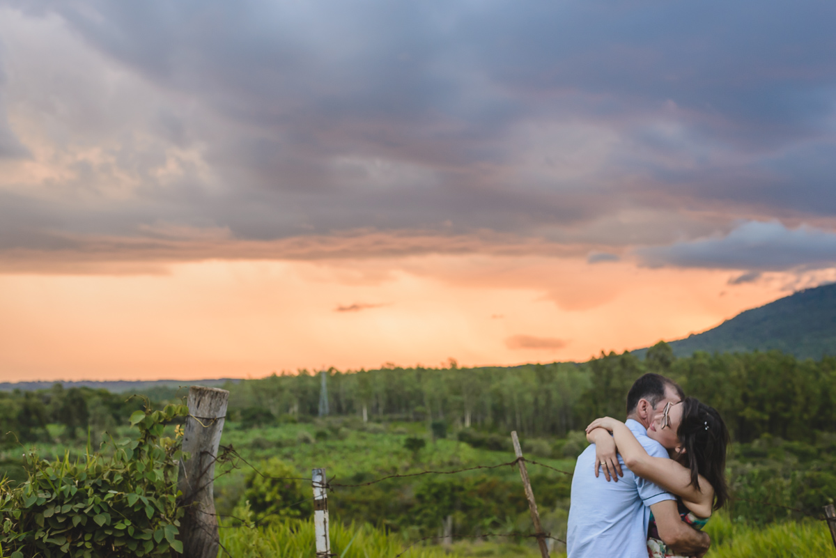 Foto do casal abraçado no campo com pôr do sol no ensaio pré wedding- Iperó - SP - fotografia Cia P&B Produções