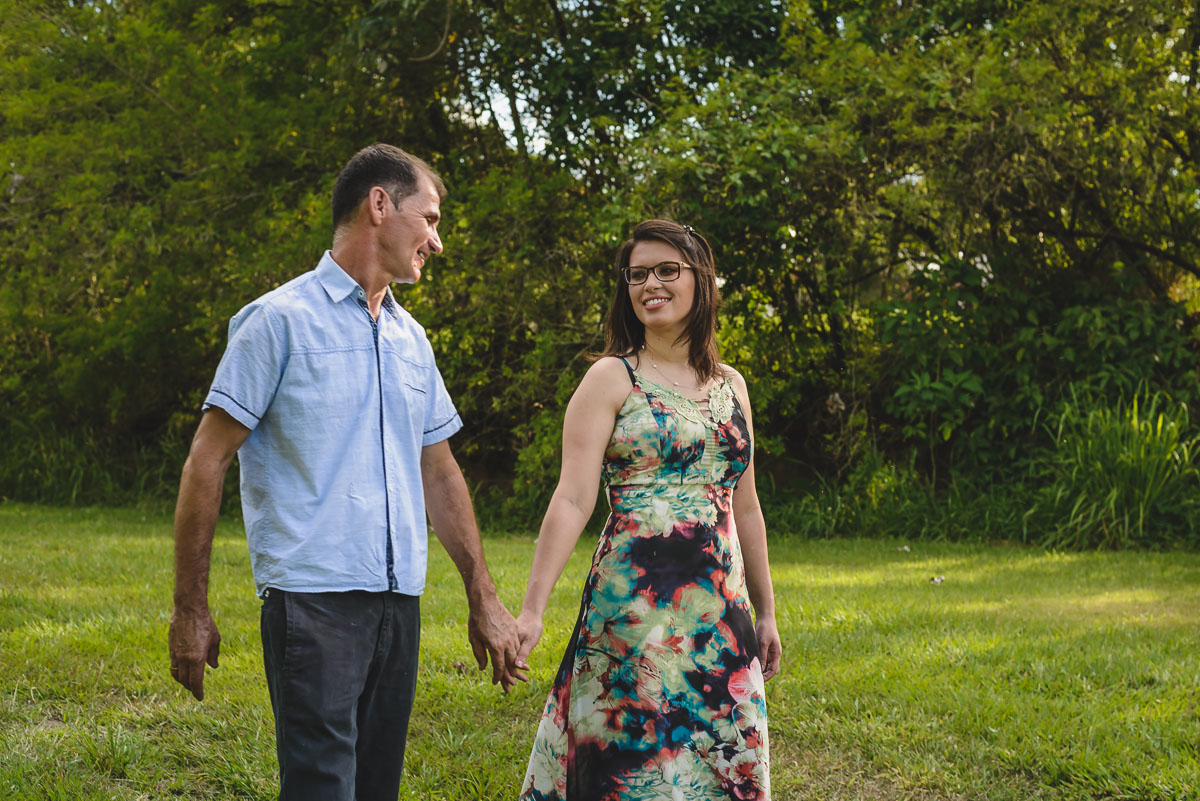 Foto do casal caminhando no campo de mãos dadas no esnaio pré wedding- Iperó - SP - fotografia Cia P&B Produções