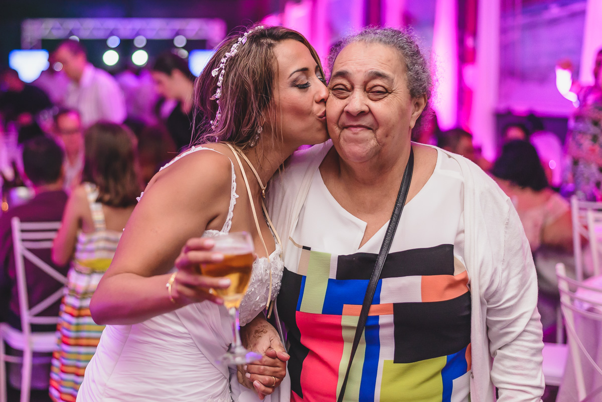 Foto da noiva dando um beijo na convidada na hora da festa- KF Eventos - Praia Grande - SP
