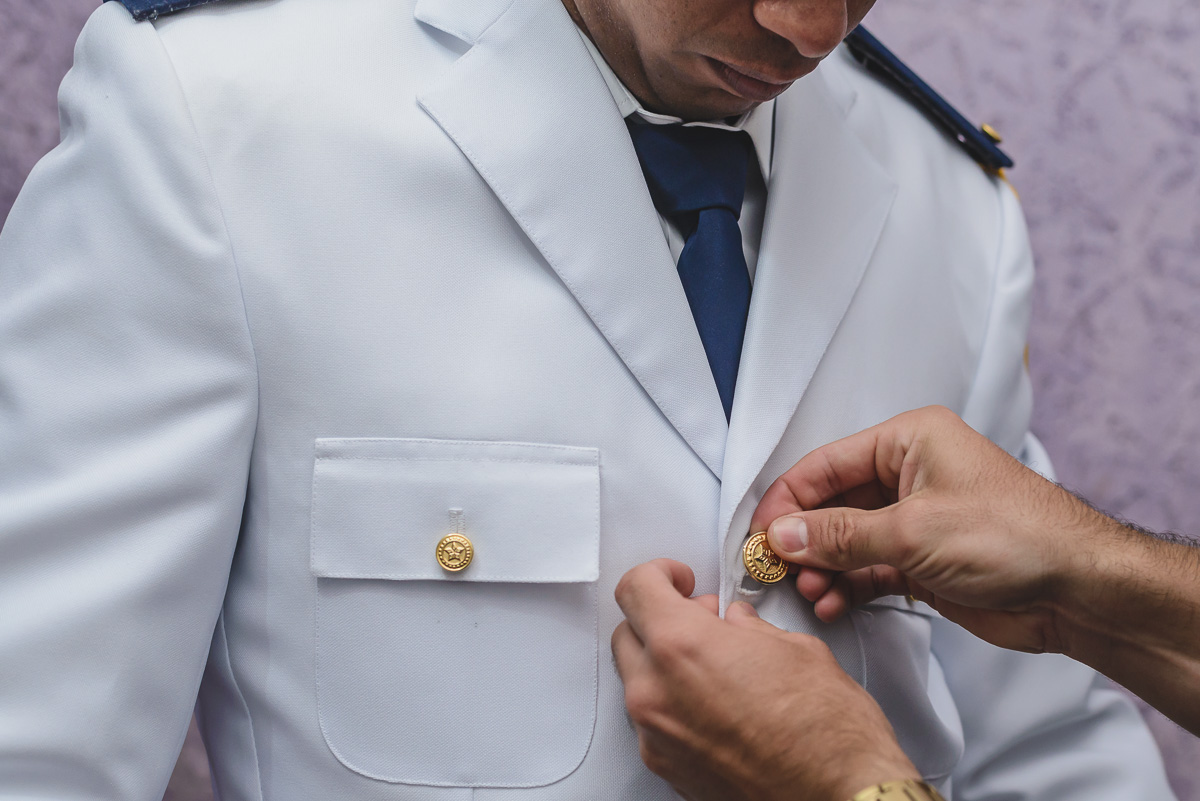 Foto do padrinho abotoando o paletó do noivo - Praia Grande -SP - Cia P&B Produções