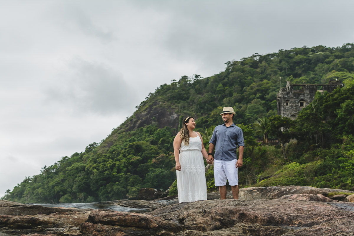 casal nas pedras em seu ensaio pré-wedding/Praia de Peruíbe - Cia P&B Produções