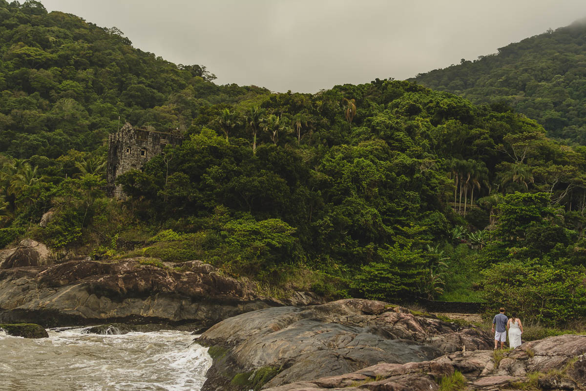 Casal caminhando nas pedras. /Praia de Peruíbe - Cia P&B Produções