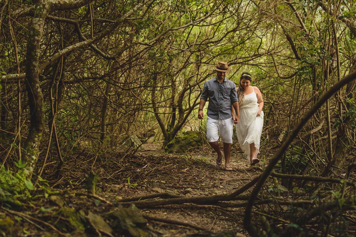 Casal caminhando entre as árvores./Praia de Peruíbe - Cia P&B Produções