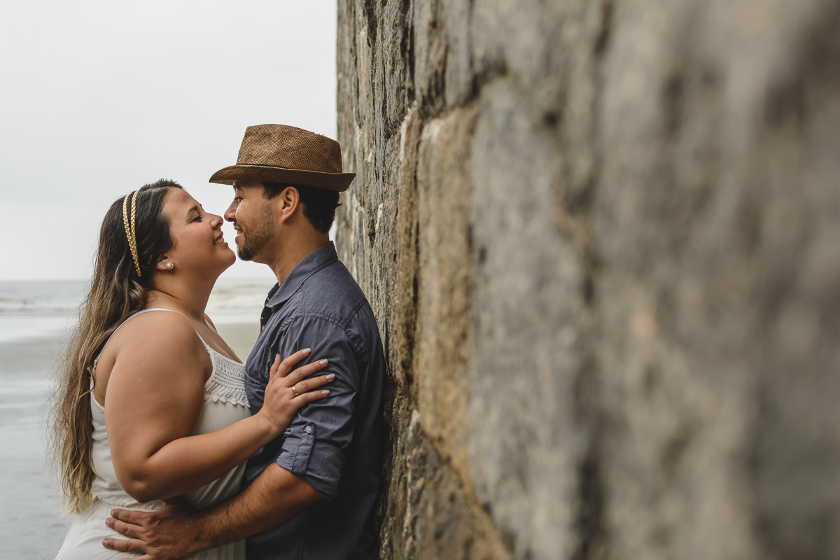 Casal encostado no muro./Praia de Peruíbe - Cia P&B Produções