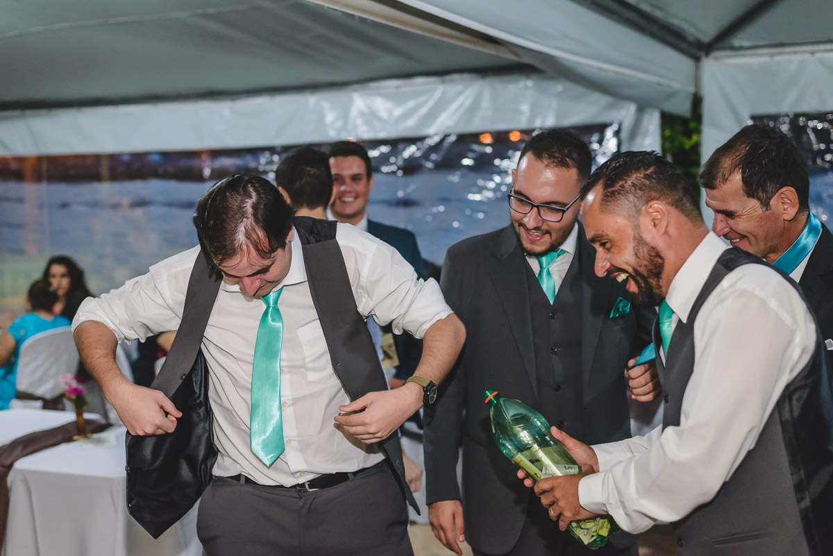 Padrinhos passando a gravata do noivo na festa- Itapevi - SP - fotografia Cia P&B Produções  - Chácara Brilho da Lua