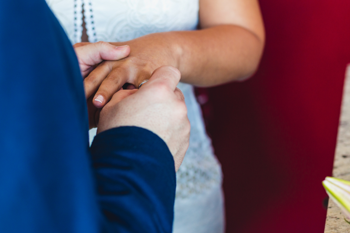 Noivo colocando aliança em noiva