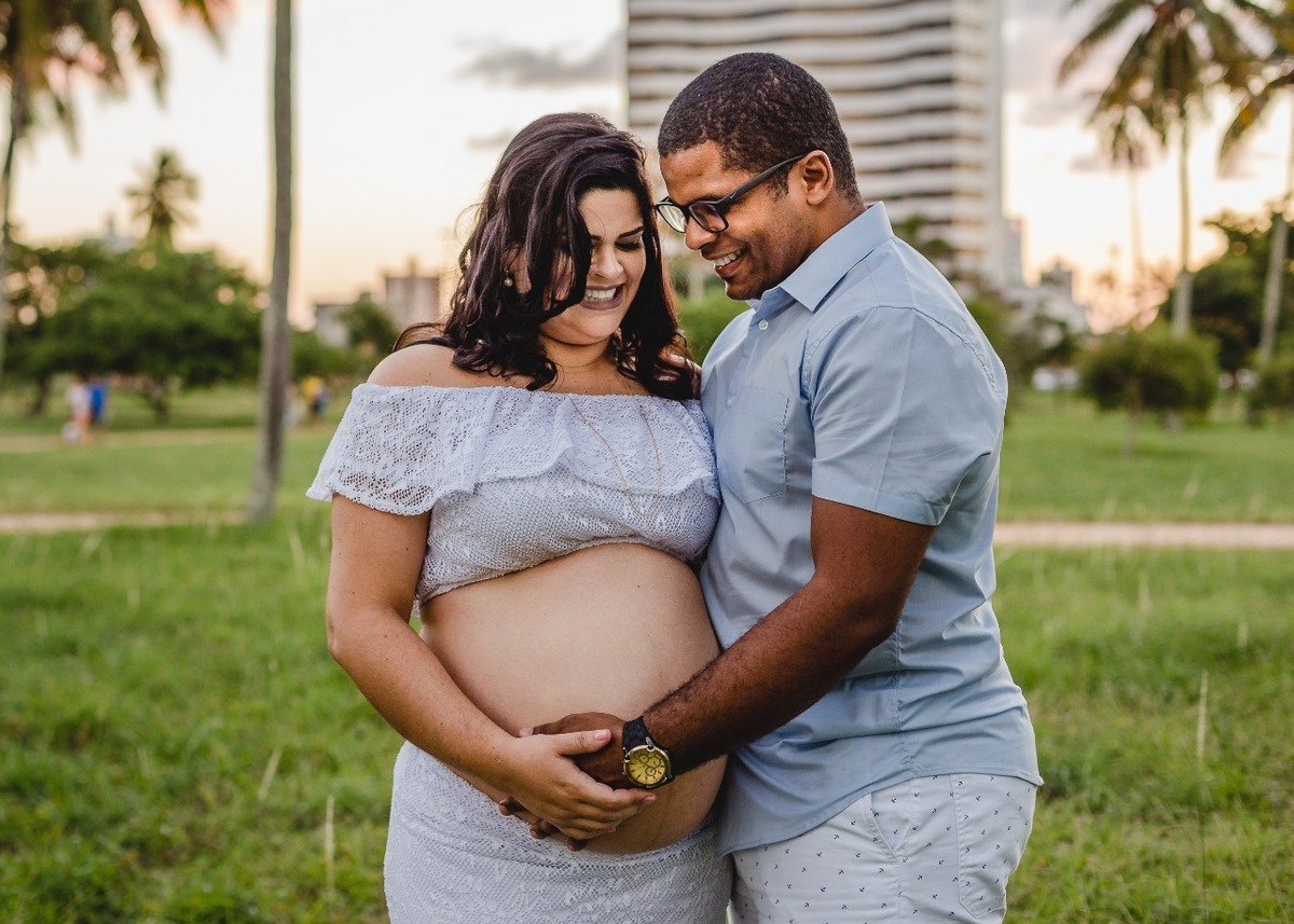 marido e esposa topando na barriga gestante