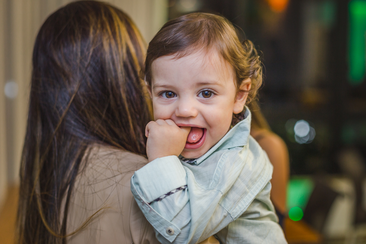 bebê nos braços da mãe, sorrindo pra foto