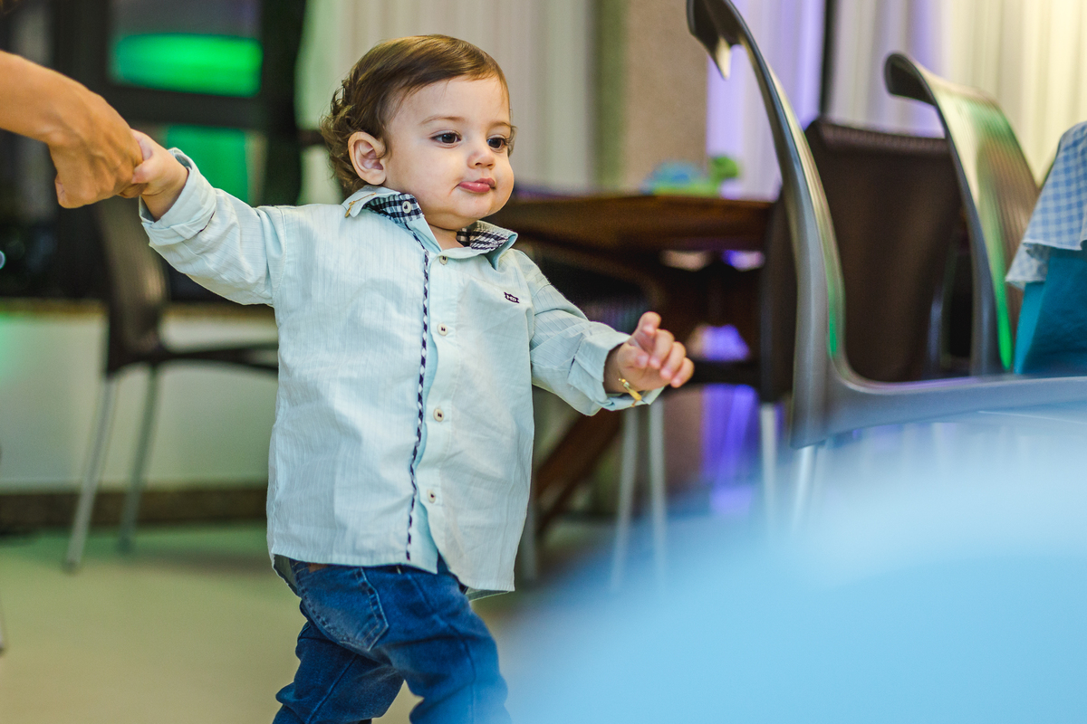 bebê segundando a mão da mãe e caminhando sozinho