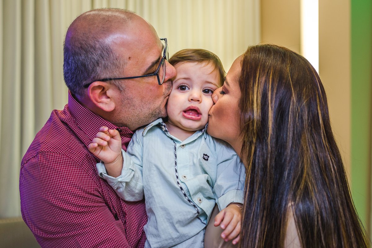 pais beijando as bochechas do filho
