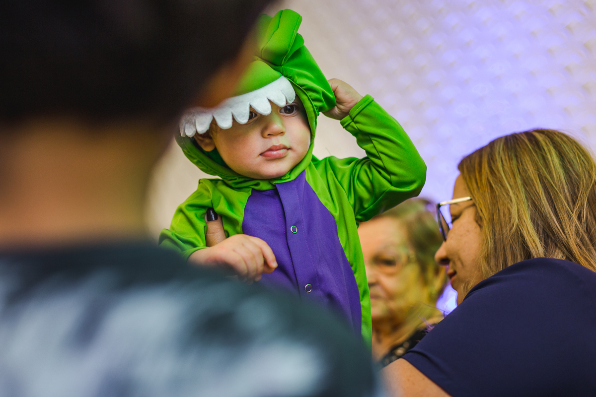 bebê vestido com roupa de dinossauro