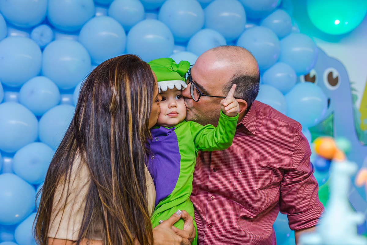 pais beijando as bochechas do filho, e filho fazendo o numero um com so dedos