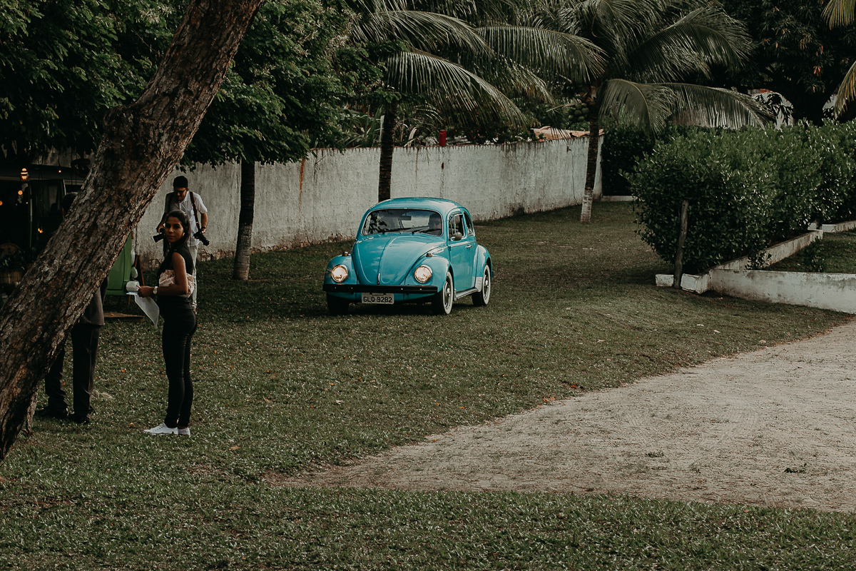 noiva chegando dentro de um fusca azul cheio de estilo