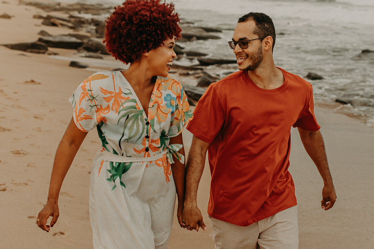 casal correndo na areia da praia