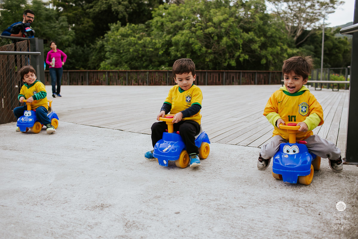Irmãos brincando de triciclo.