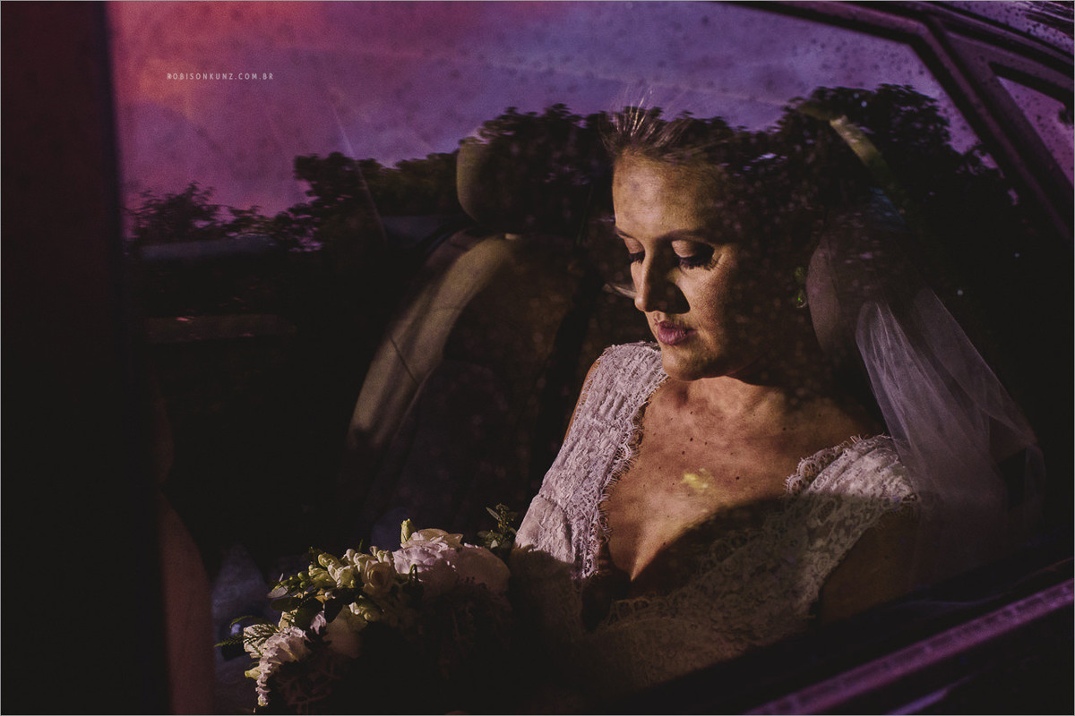 noiva esperando no carro com chuva