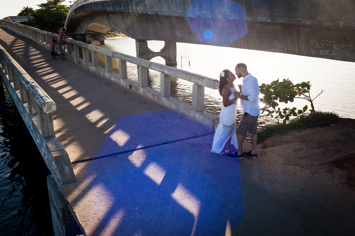 casal de mãos dadas na ponte, com raio solar na lente.