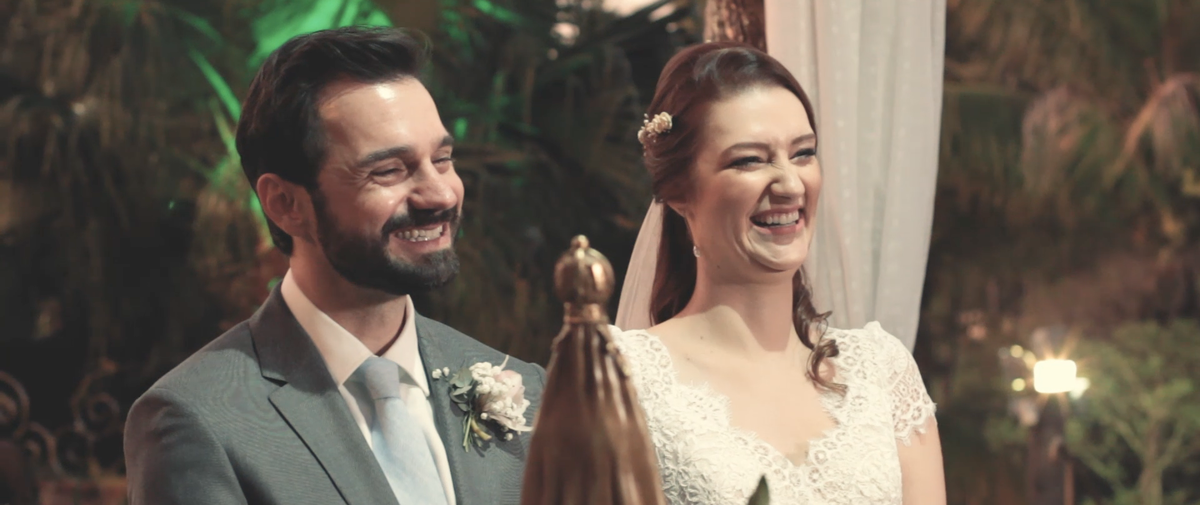 Aline e Juliano sorriem felizes em seu casamento. A fé esteve muito presente na união desse casal devoto de Nossa Senhora Aparecida.