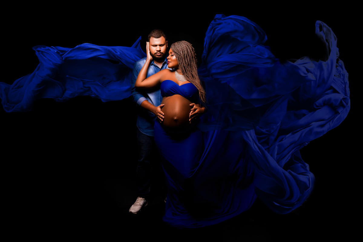 Em um momento de pura serenidade, Larissa Lacerda é capturada em uma fotografia emocionante, envolta em um tecido esvoaçante na cor azul. O tecido dança ao vento, acrescentando um toque de magia e mistério à cena.