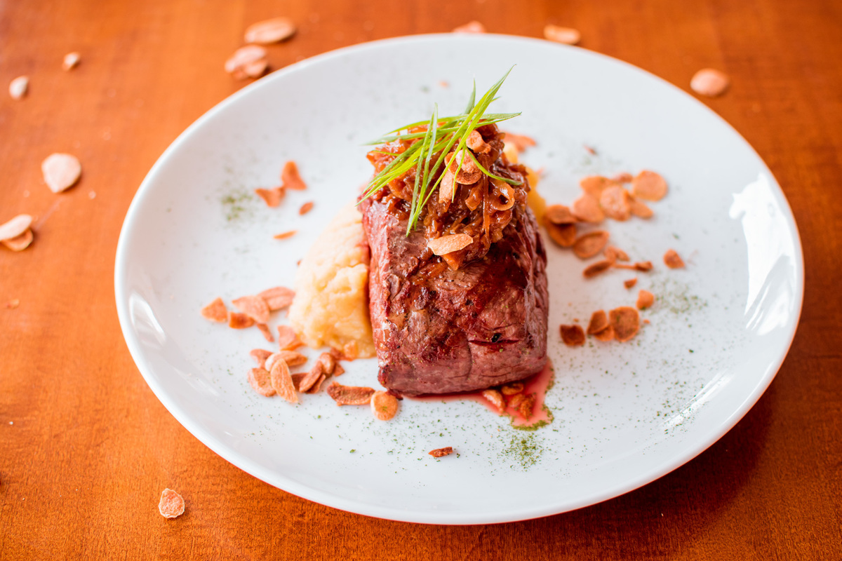 Filé mignon grelhado, purê de batata doce, cebola caramelizada e chips de alho.
