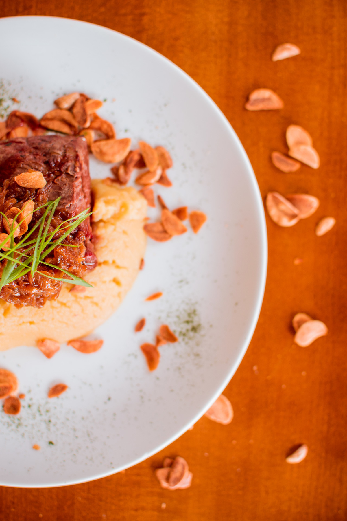 Filé mignon grelhado, purê de batata doce, cebola caramelizada e chips de alho.