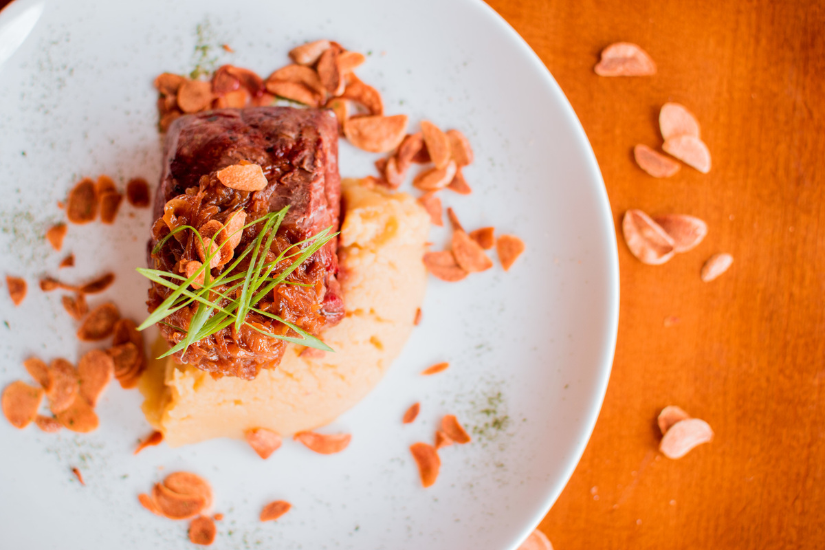 Filé mignon grelhado, purê de batata doce, cebola caramelizada e chips de alho.