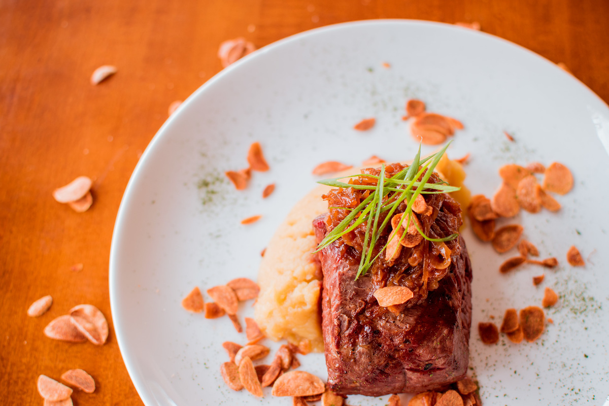 Filé mignon grelhado, purê de batata doce, cebola caramelizada e chips de alho.