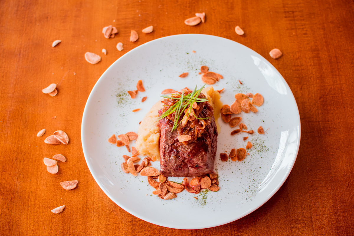Filé mignon grelhado, purê de batata doce, cebola caramelizada e chips de alho.