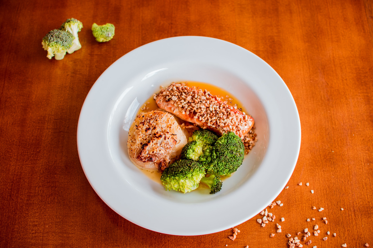 Salmão grelhado em crosta de castanha de caju, mil folhas de batata e molho de laranja com gengibre.