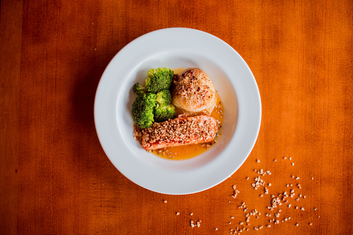 Salmão grelhado em crosta de castanha de caju, mil folhas de batata e molho de laranja com gengibre.