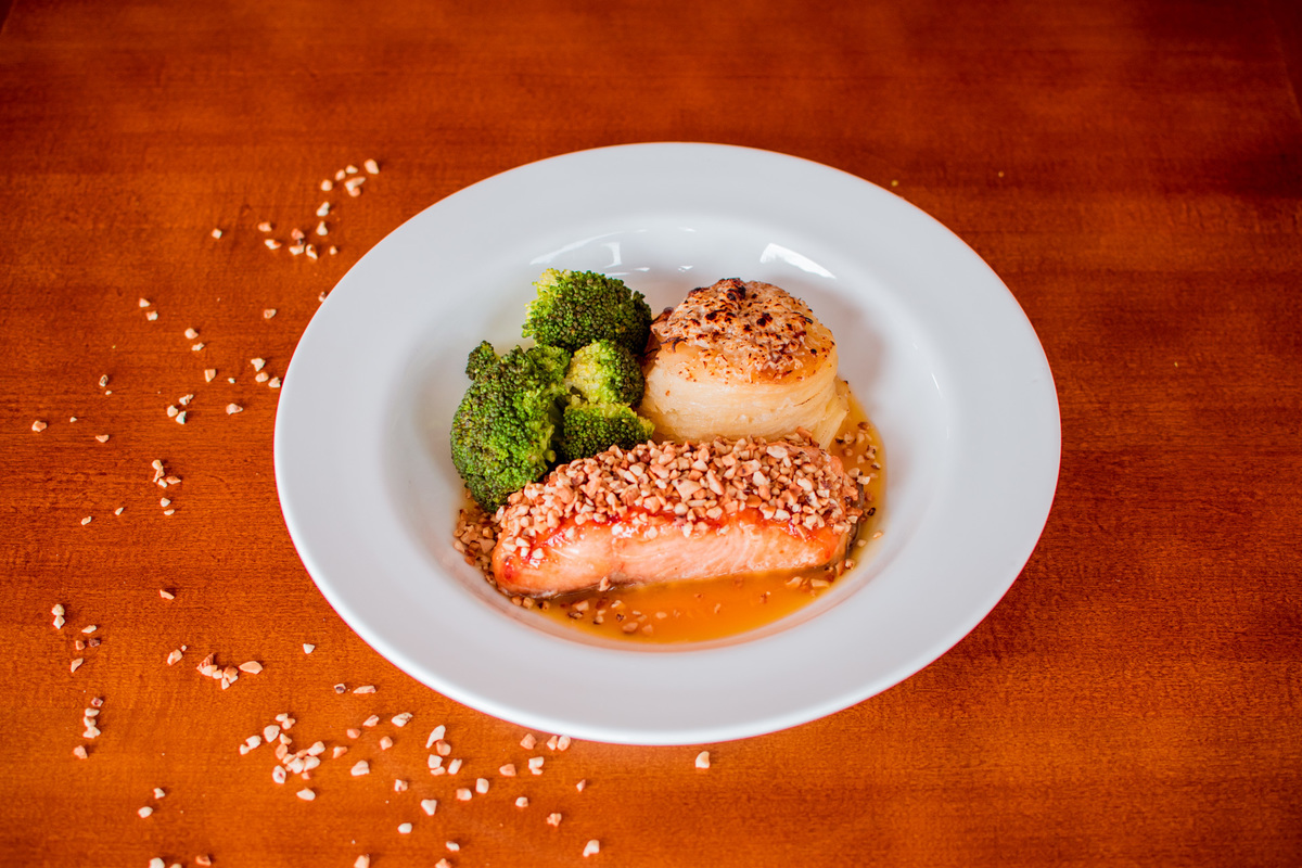 Salmão grelhado em crosta de castanha de caju, mil folhas de batata e molho de laranja com gengibre.