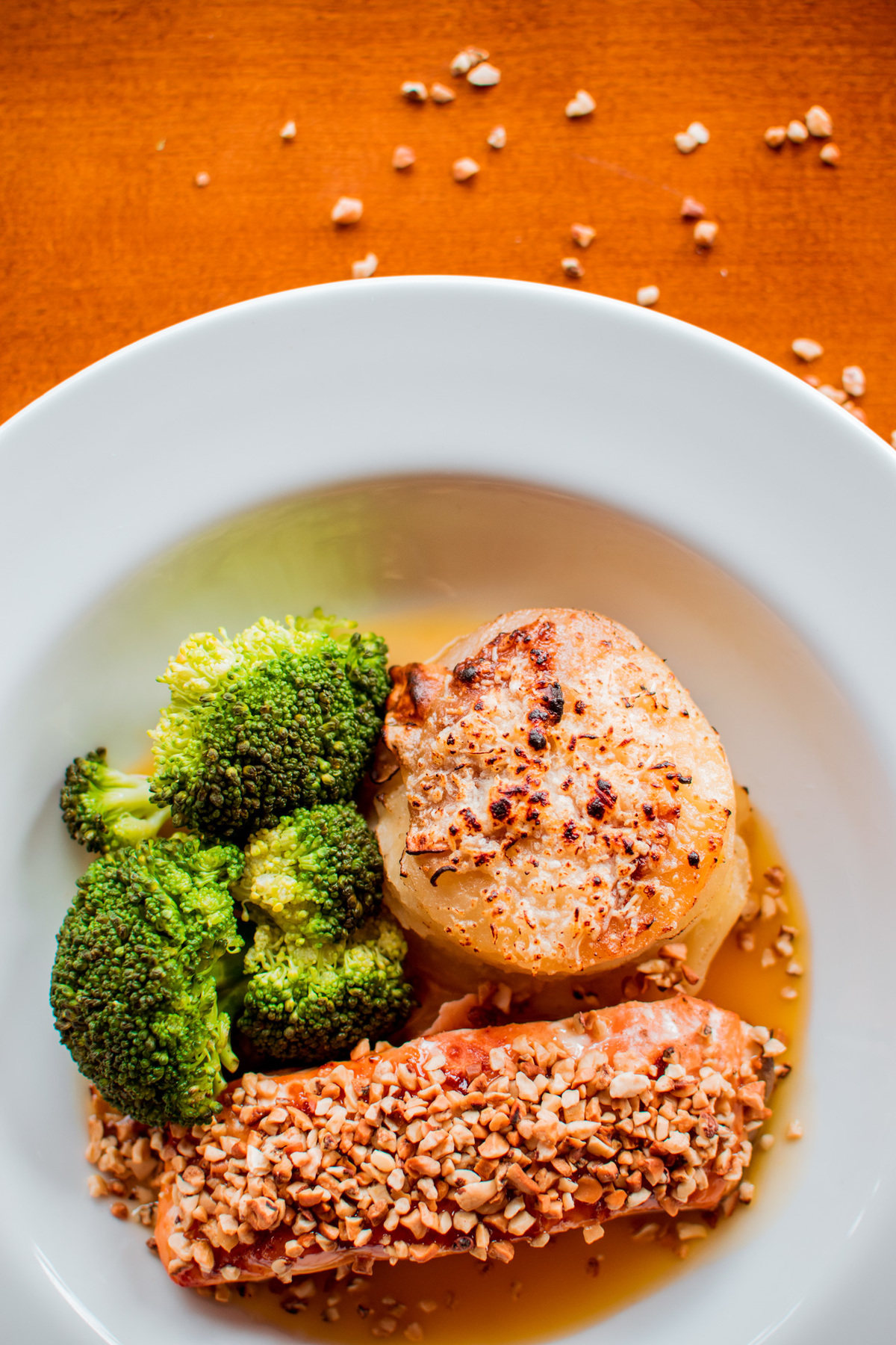 Salmão grelhado em crosta de castanha de caju, mil folhas de batata e molho de laranja com gengibre.