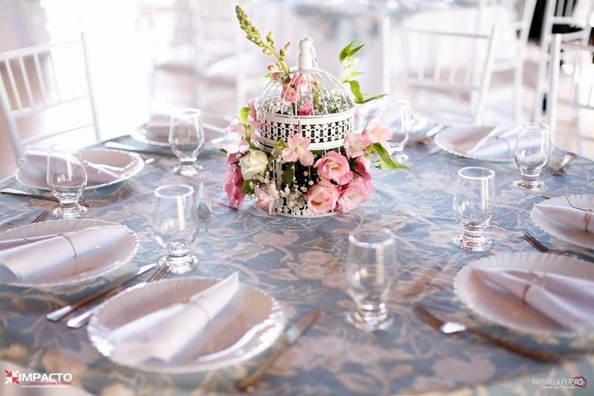 Centro de mesa com gaiola branca e arranjo floral