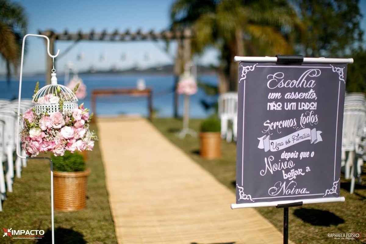 Corredor de casamento com tapete rústico e arranjos suspensos com gaiolas brancas