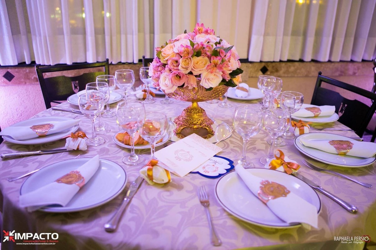 Centro de mesa de casamento com arranjo floral rosa em base dourada