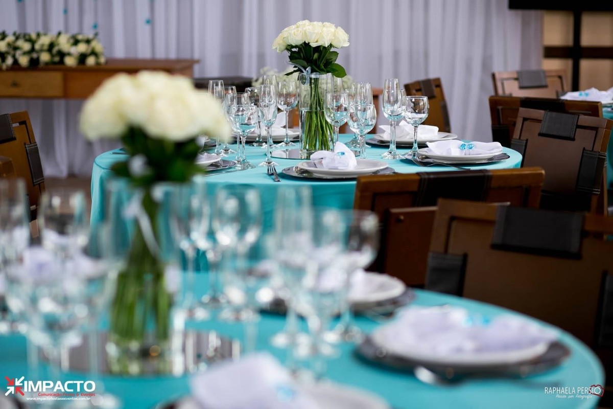 toalhas azul tiffany pratos com sousplat de inox prateados arranjo de flores