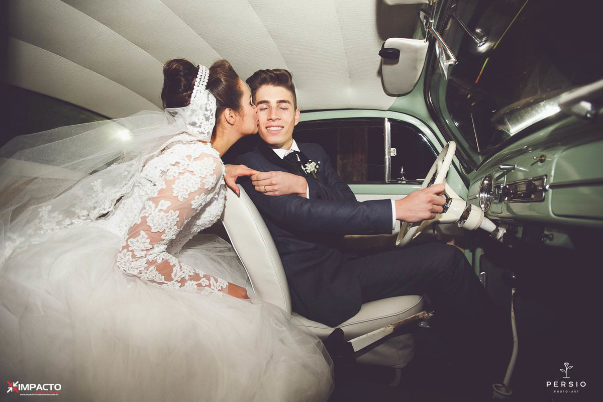 Foto da noiva dando um beijo no noivo dentro do fusca