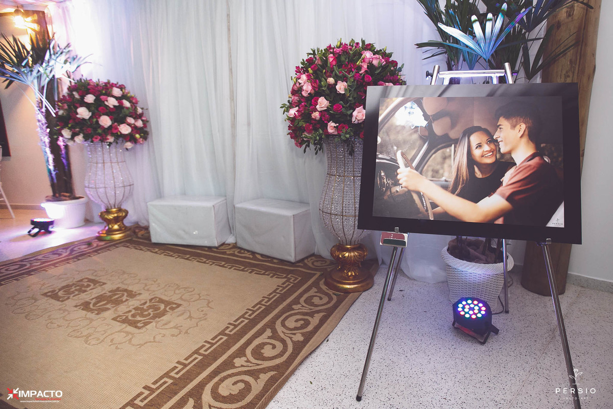 espaço para fotos com arranjos florais e poster dos noivos