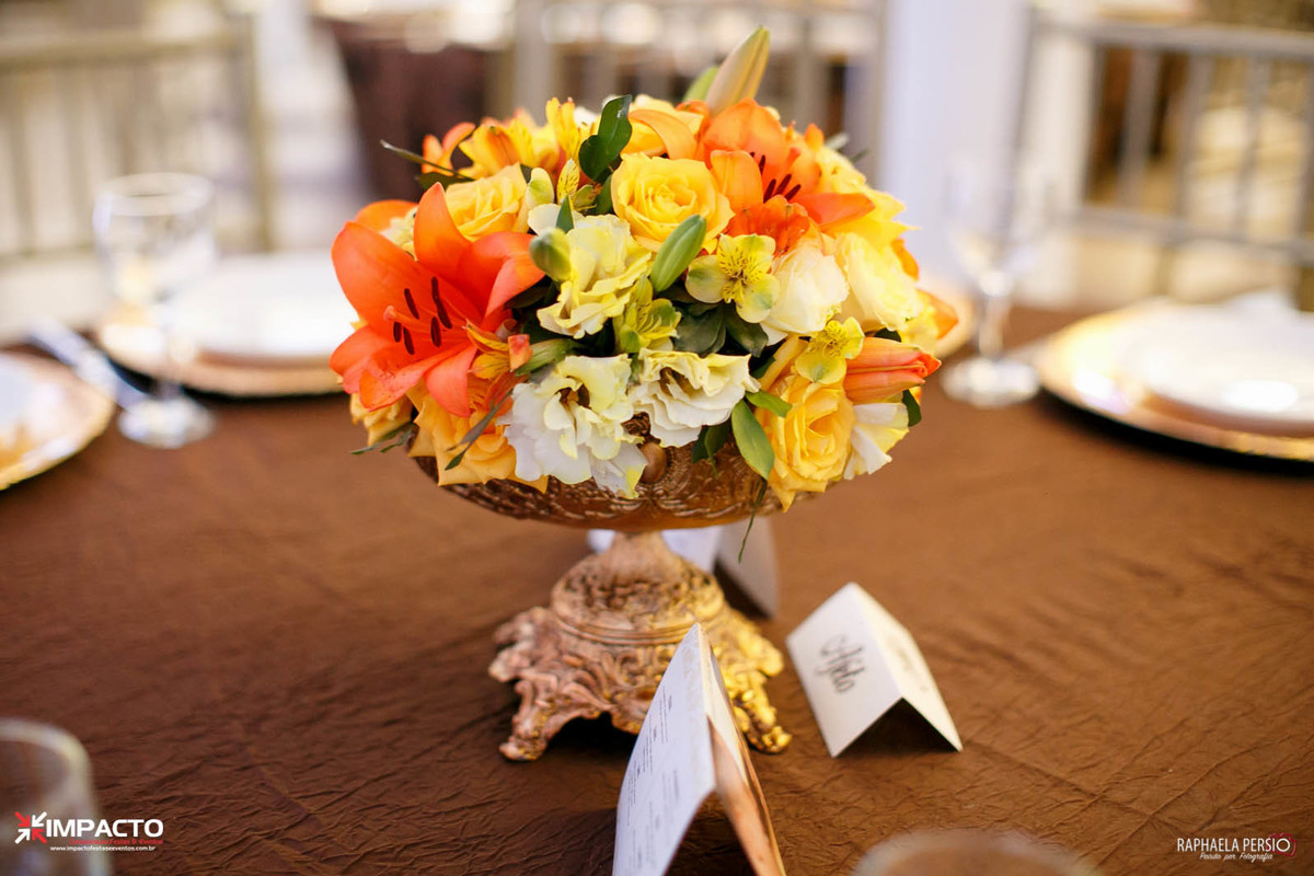 arranjo de mesa casamento na base dourada com flores laranja e amarelo