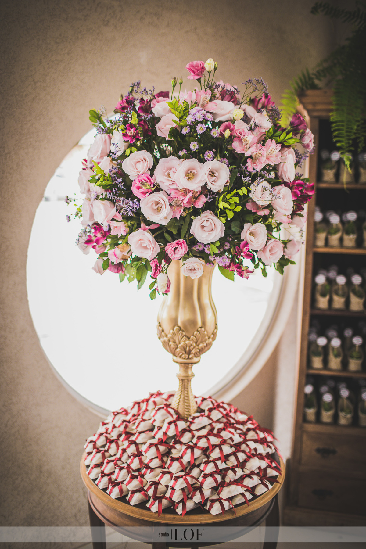 Arranjo mesa de doces com flores marsala e rosa e vaso dourado