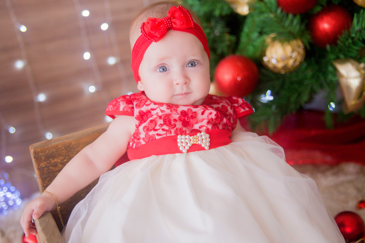 os olhos azuis da bebê se destacam sem sua sessão de natal