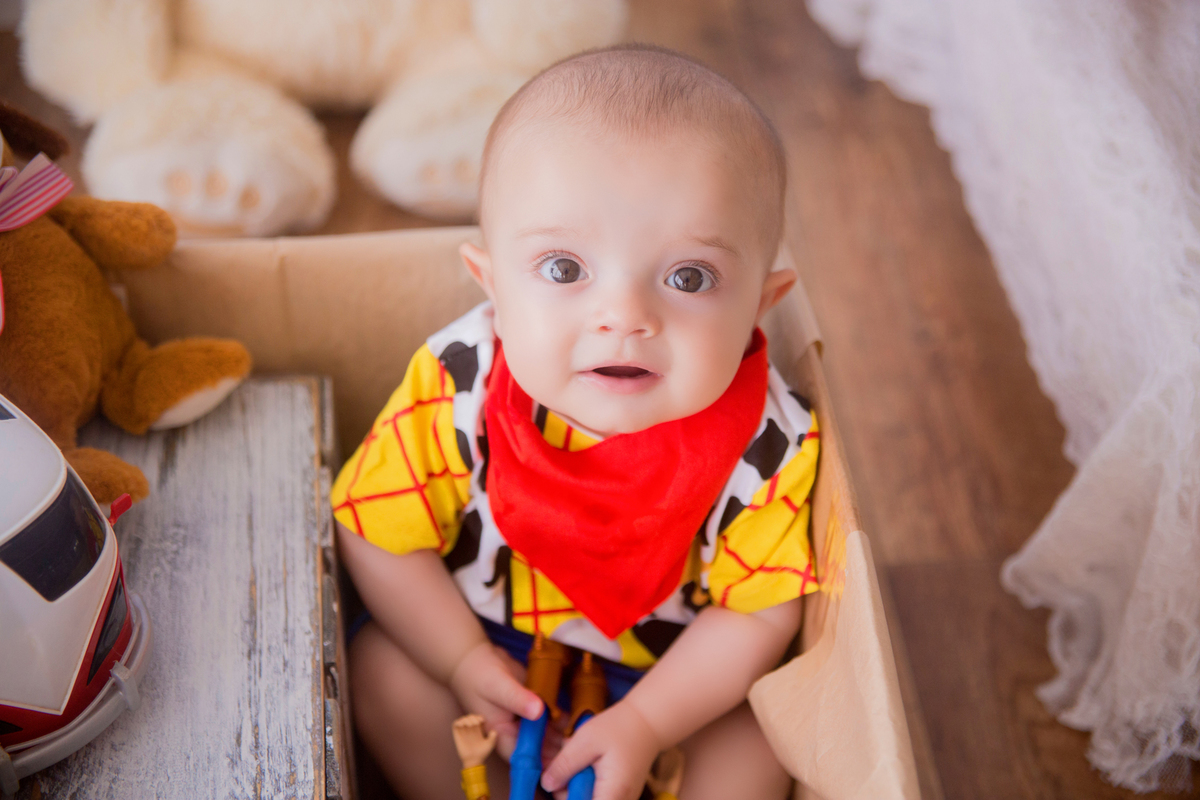 o bebê olha para a fotógrafa em sua sessão de acompanhamento