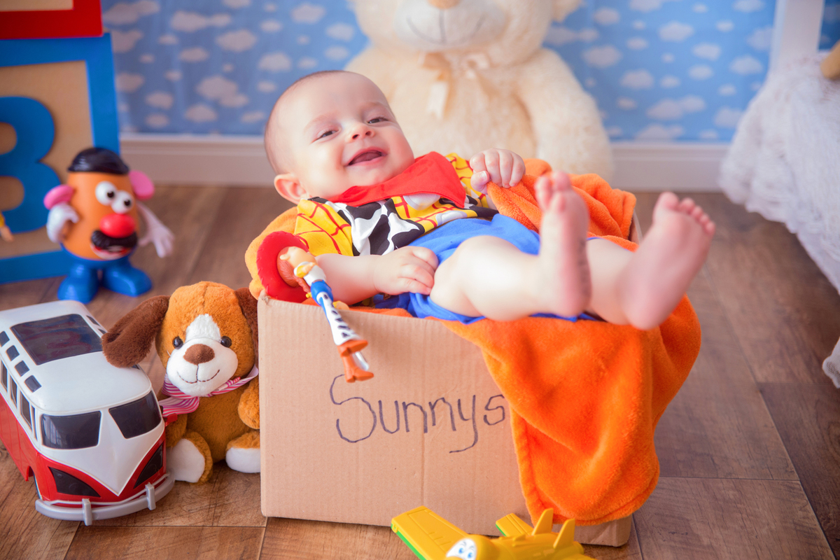 o bebê menino sorri deitado dentro da caixa